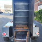 Used Meadow Creek TS120 Tank Smoker With Live Smoke, Insulated Firebox, Stainless Steel Exterior Shelves & Extra Grate in Warming Box